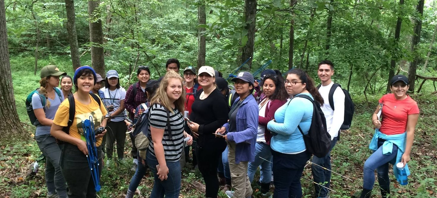 students in a forest looking toward the camera
